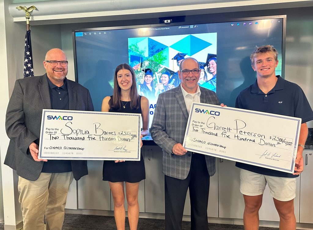 The scholarship winners holding giant checks