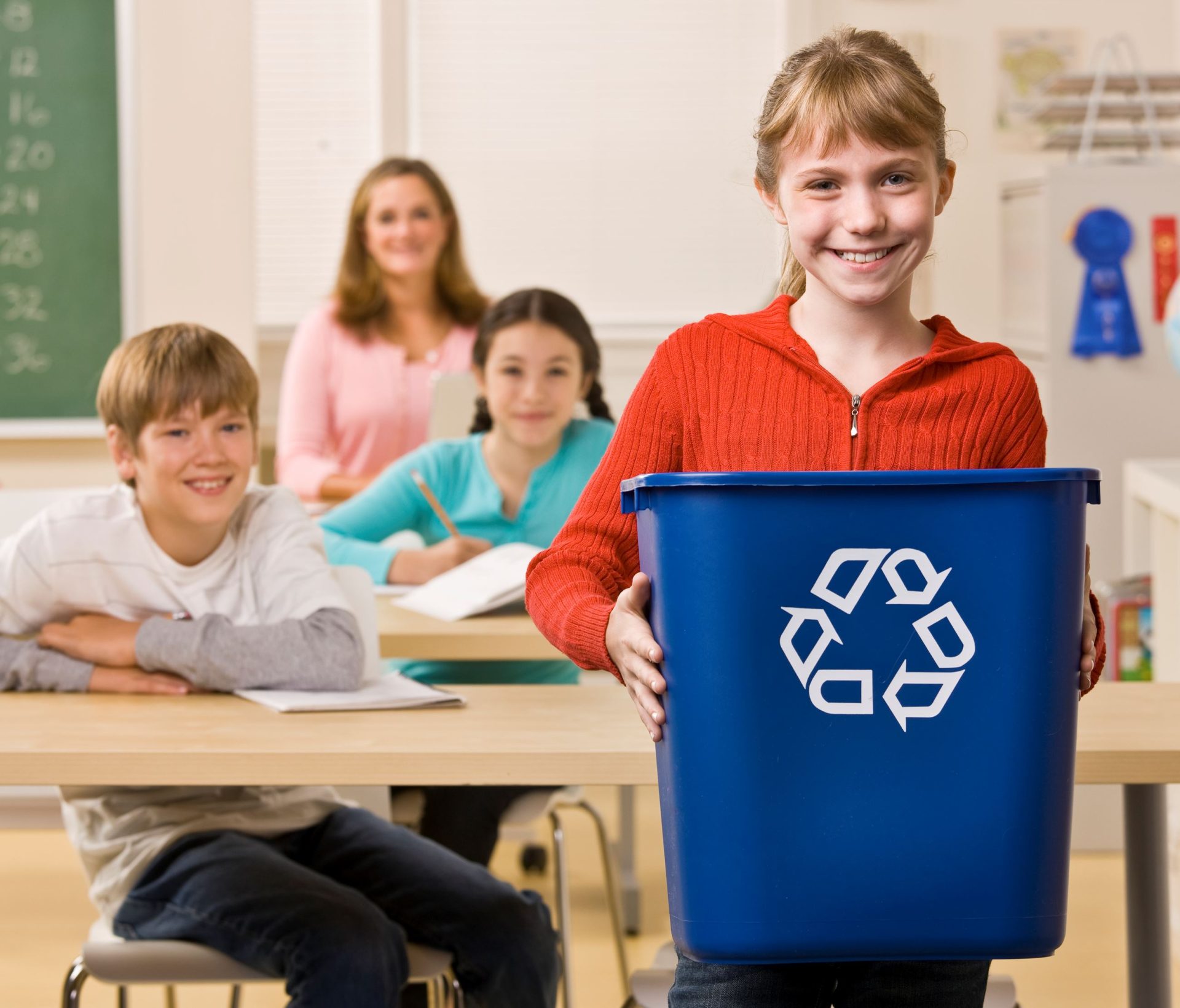 Girl in classroom with Recycling Bin