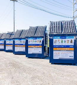 A row of blue dumpsters