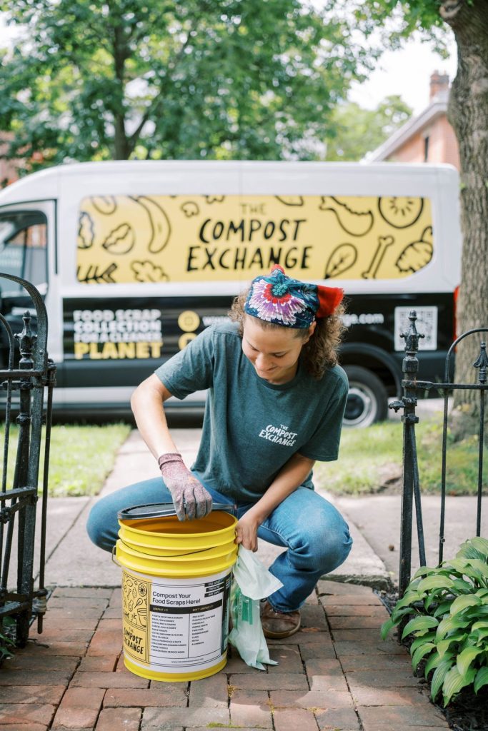 A woman with a compost bucket in front of a Compost Exchange truck.