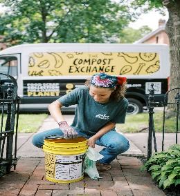 A woman holding a compost bucket
