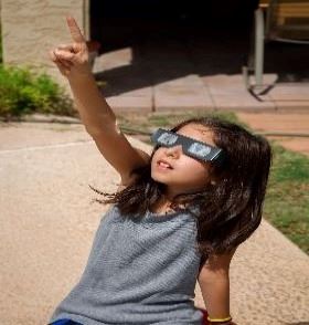 Kid pointing at a solar eclipse