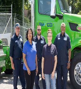 Five people standing in front of a truck.