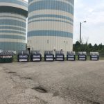 Dumpsters with water towers behind them.