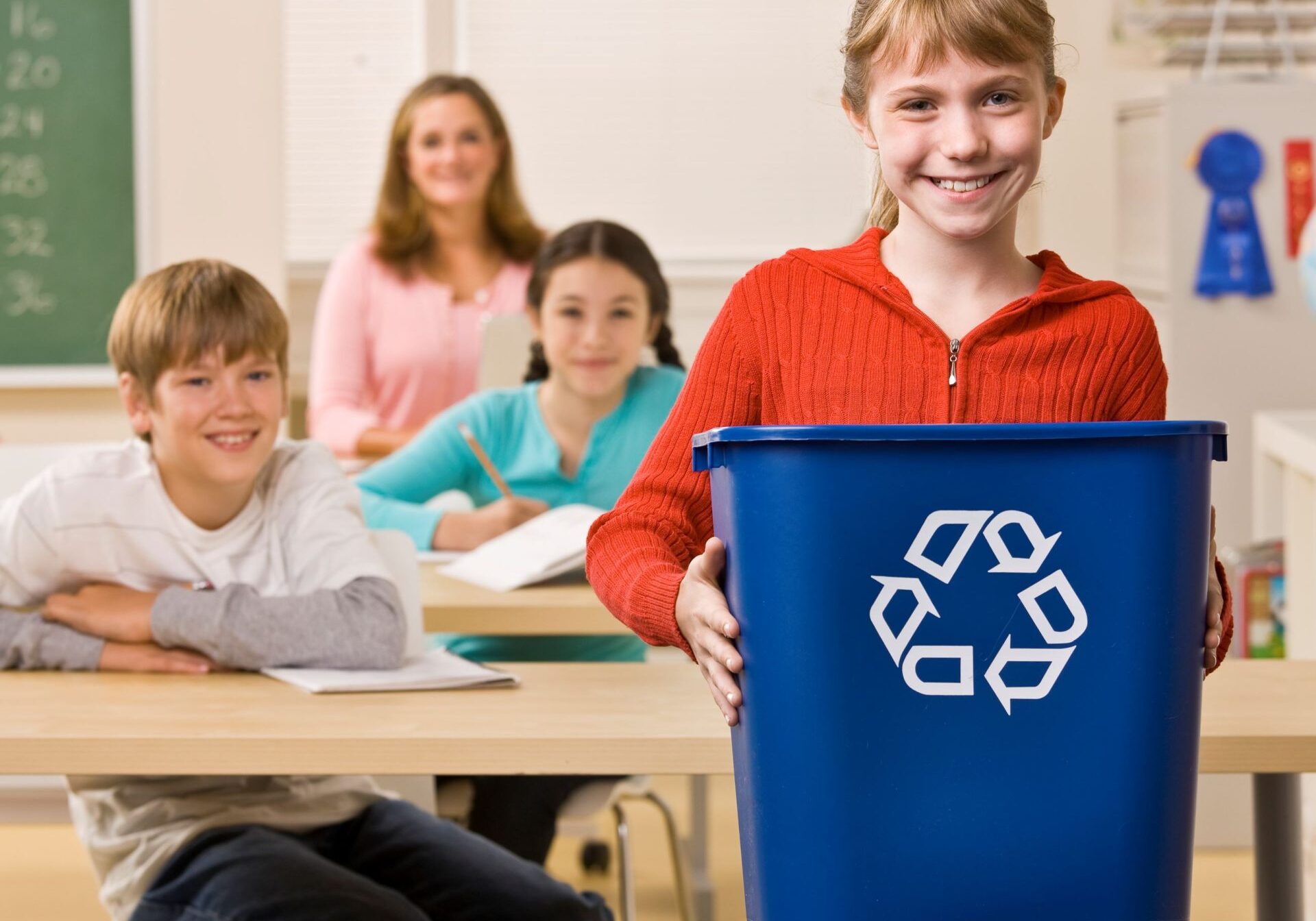 Girl in classroom with Recycling Bin