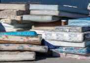 Dirty used mattresses piled at recycling site.